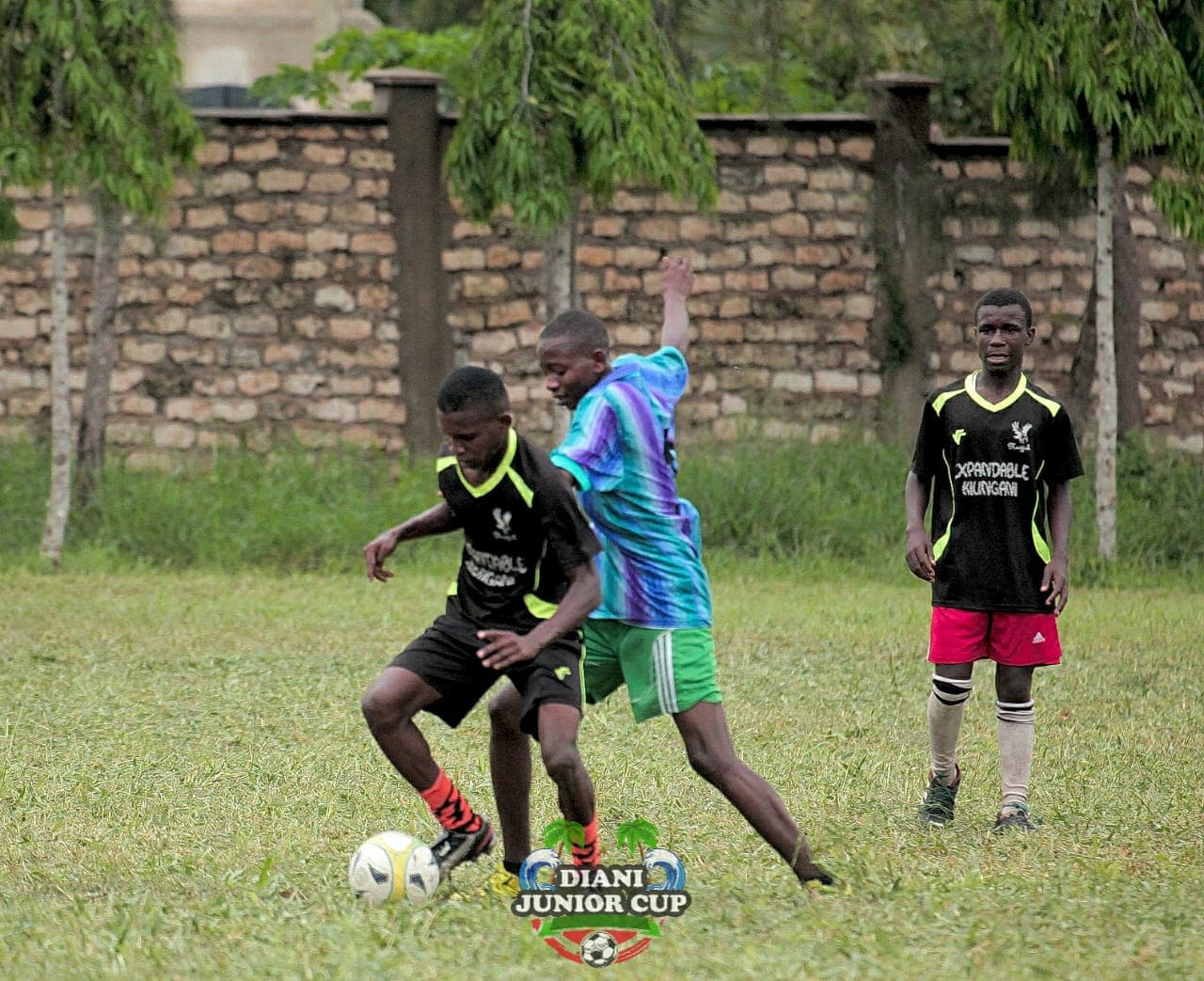 Two youth footballers contesting the ball during a DJC fixture.