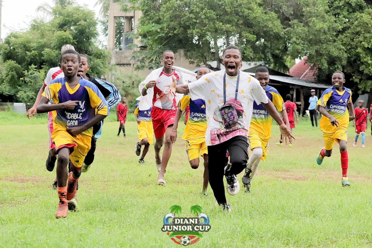DJC players and coaches running together in celebration.