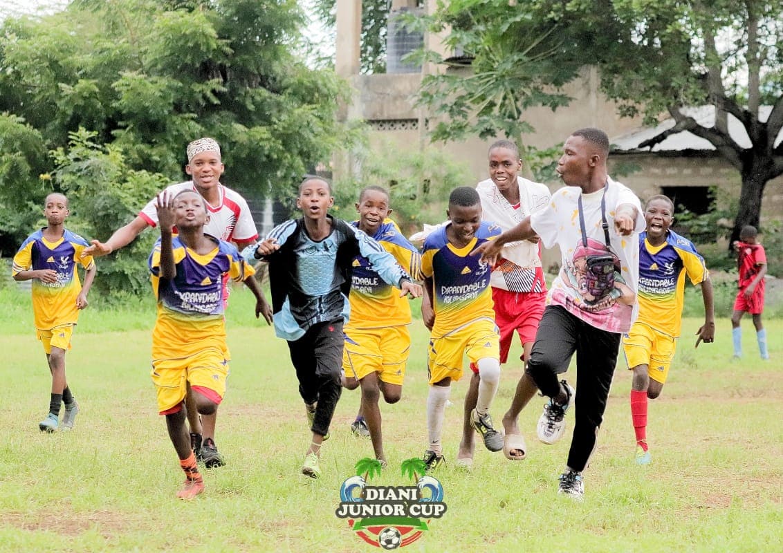 Players and coaches running in celebration at Diani Junior Cup.