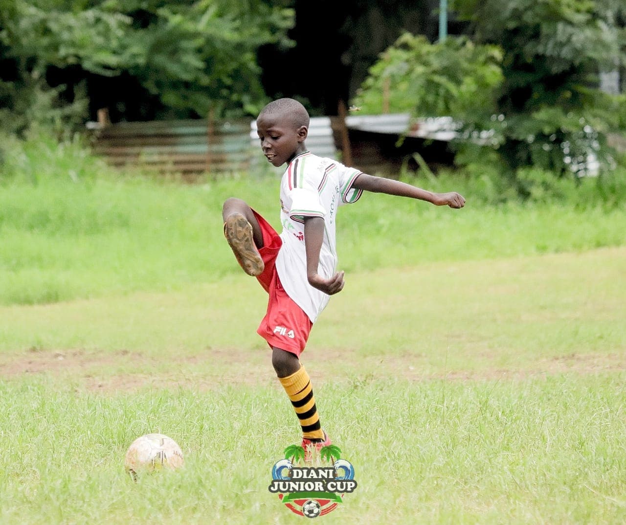 A young DJC player preparing to strike the football.