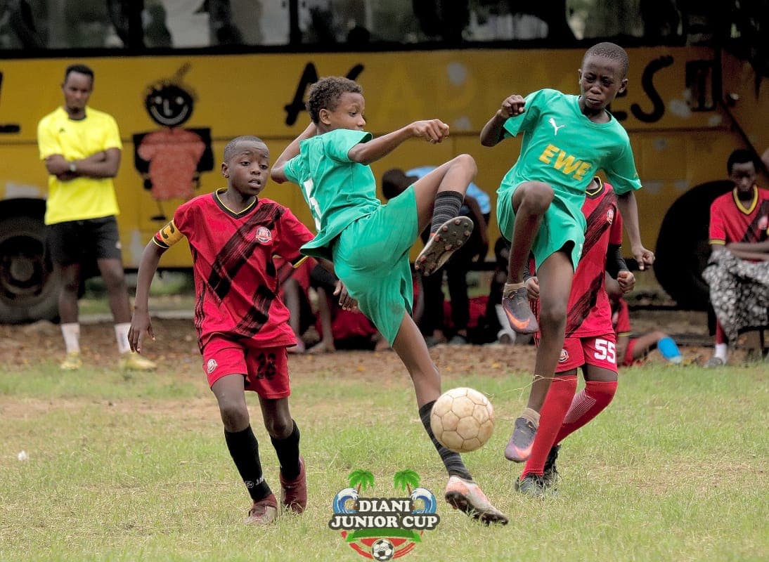 Young footballers contesting possession during DJC match play.