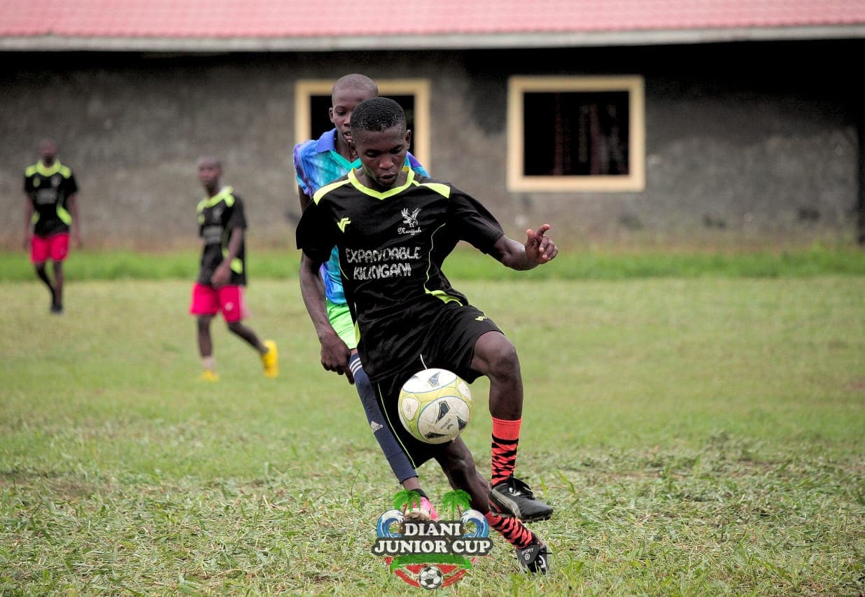 A youth footballer controlling the ball during a DJC fixture.